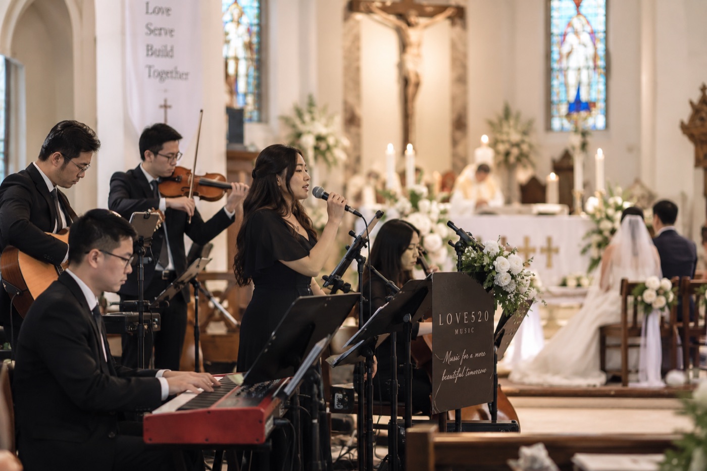 520 The Wedding Singers performing live during a Catholic wedding ceremony in a Singapore church, with vocalist, pianist, violinist and guitarist beside the altar.